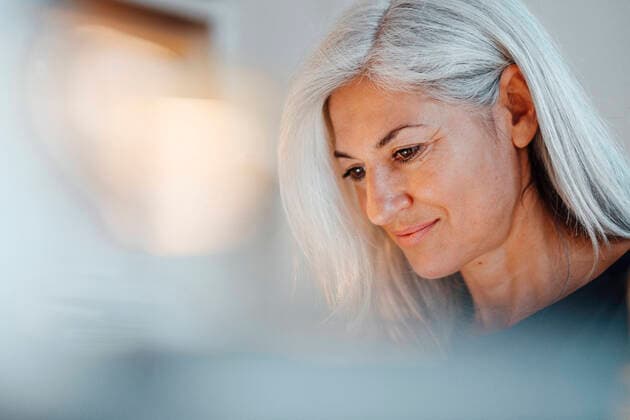 IMAGO Creative: Internationaler Frauenmonat, Gesundheit, Frauen in der Menopause Mature businesswoman with white hair looking down at office model released Symbolfoto property released JOSEF05029