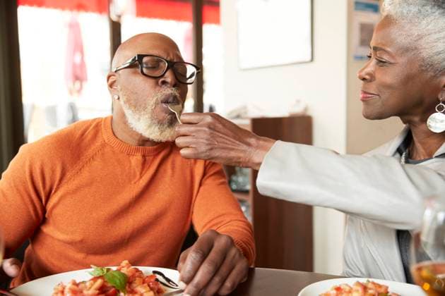 Woman feeding man with fork in restaurant model released Symbolfoto property released PMF02052