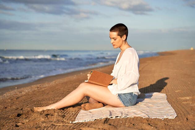 IMAGO Creative: Bildung, Schreiben Woman writing in diary while sitting on blanket model released Symbolfoto VEGF04752