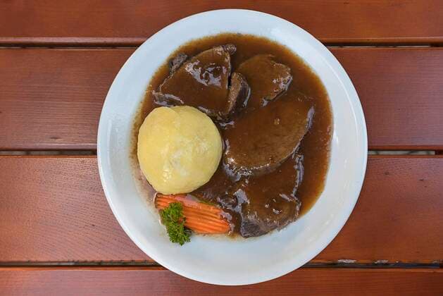 Sauerbraten mit Soße und Kloß im Biergarten serviert, Bayern, Deutschland, Europa *** Sauerbraten with gravy and dumpling served in beer garden, Bavaria, Germany, Europe Copyright: imageBROKER/MeyerxzurxCapellen ibxmzc07127543.jpg