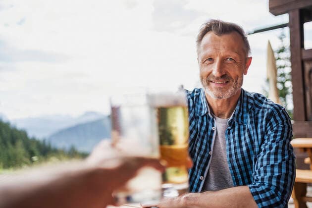 Smiling man toasting beer glass with friend at bar model released Symbolfoto DIGF16313