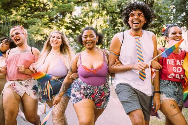 IMAGO Creative: Pride Month 2022, Aktivismus Happy male and female protesters holding hands in pride event model released Symbolfoto MEUF03658