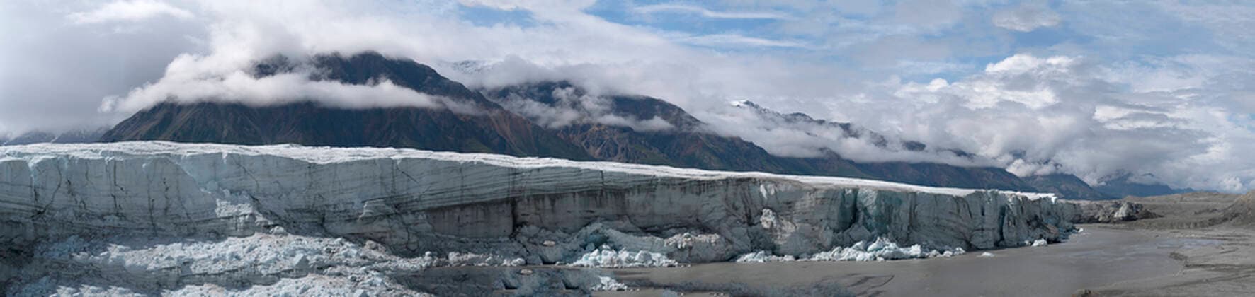 The vast Donjek Glacier in Kluane National Park with a blue sky and misty clouds over the mountaintops, situated in the Traditional Territory of the Champagne and Aishihik First Nations; Kluane National Park and Reserve, Yukon, Canada  Copyright: RobertxPostma 33349495