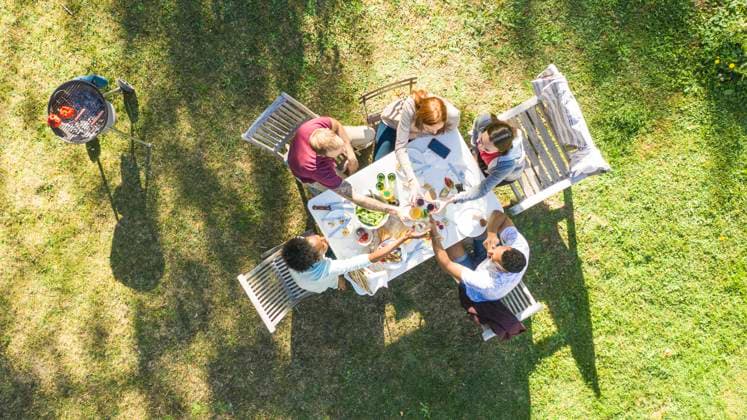 Happy young friends toasting beer bottles in garden Copyright: GabrielxSanchez B86009844