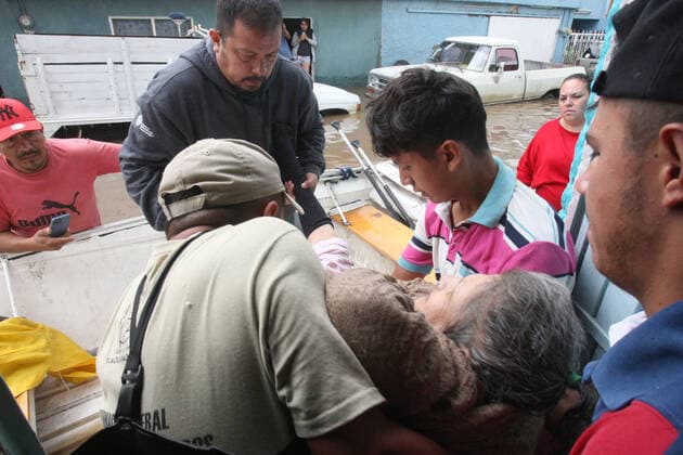 (210904) -- JALISCO, Sept. 4, 2021 -- People help a woman get on a lifeboat on a street flooded due to heavy rains, in the municipality of Tlaquepaque, State of Jalisco, Mexico, on Sept. 3, 2021. A strong storm during the early hours of Friday caused the El Chicharron and Las Pintas dams to overflow, flooding several areas of the municipality of Tlaquepaque. ) MEXICO-JALISCO-FLOOD ArturoxCampos 