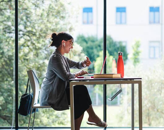 Tschechien, Hochschule streicht wegen KI und Plagiate Bachelorarbeiten Side view of female student looking her watch on while sitting at table with book and doing homework in university library, Model released AlbertMorcillo_GraphicDesigner_4.jpg Copyright: xAlbertxMorcillox MR