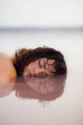 IMAGO Creative: Dichotomien, Reflexionen IMAGO Creative: Frauenmonat im M?rz Tranquil female with closed eyes lying with half of face in water of pink pond in summer, Model released LeoPastor_PinkLake_13.jpg Copyright: xLeoxPastorx MR