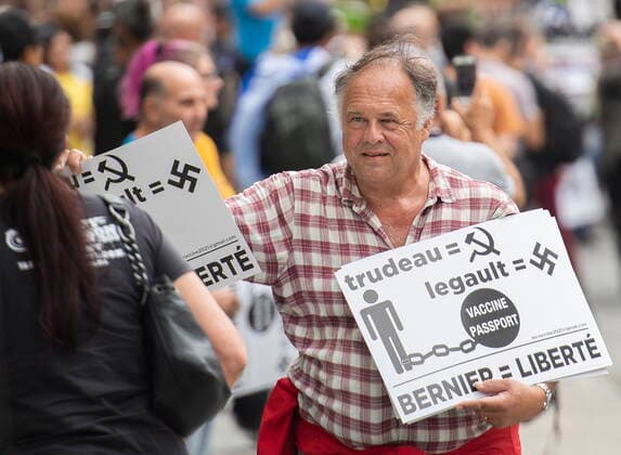 September 5, 2021, Montreal, PQ, Canada: A man hands out signs during a protest against the Quebec governmentÃ¢â‚¬â ¢s measures to help curb the spread of COVID-19 in Montreal, Sunday, September 5, 2021, as the COVID-19 pandemic continues in Canada and around the world. Montreal Canada  - ZUMAc35_ 20210905_zaf_c35_039 Copyright: xGrahamxHughesx
