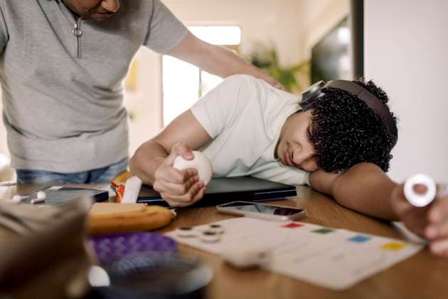IMAGO Creative: 2021 Trends Father looking at exhausted son resting over table at home Sweden, Stockholm, model released, property released Copyright: xMaskotx , MA88393