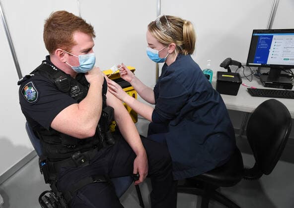 QLD CORONAVIRUS COVID19, Queensland Police officer Senior Constable Daniel Horne (left) is seen getting the COVID-19 vaccination at the new vaccination hub at the Brisbane Entertainment Centre in Brisbane, Tuesday, September 7, 2021. The Queensland government is trying to ramp up COVID-19 vaccinations before Delta reappears in the state, after bringing another outbreak under control. ( NO ARCHIVING, EDITORIAL USE ONLY, NO USE IN BOOKS WITHOUT CONSENT BRISBANE QLD AUSTRALIA  Copyright: xDARRENxENGLANDx 20210907001573541158