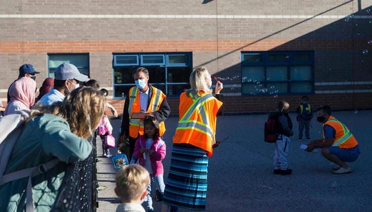 (210909) -- MISSISSAUGA (CANADA), Sept. 9, 2021 -- A teacher blows bubbles to welcome students at a school in Mississauga, the Greater Toronto Area, Ontario, Canada, on Sept. 9, 2021. Schools in Toronto, Peel, York and Durham started their school years on Thursday, offering a mix of in-person classes and online learning for students. (Photo by Xinhua) CANADA-ONTARIO-MISSISSAUGA-COVID-19-SCHOOL-OPENING DAY ZouxZheng