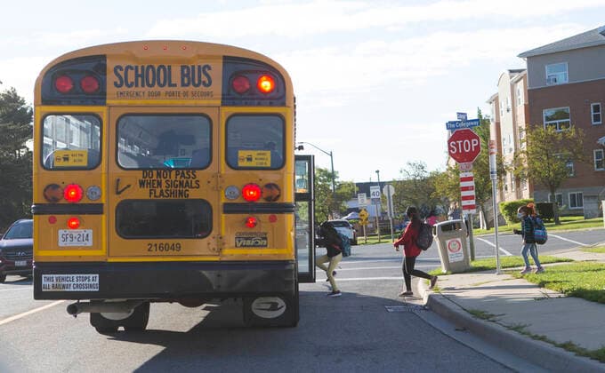 (210909) -- MISSISSAUGA (CANADA), Sept. 9, 2021 -- Students wearing face masks get on a school bus in Mississauga, the Greater Toronto Area, Ontario, Canada, on Sept. 9, 2021. Schools in Toronto, Peel, York and Durham started their school years on Thursday, offering a mix of in-person classes and online learning for students. (Photo by Xinhua) CANADA-ONTARIO-MISSISSAUGA-COVID-19-SCHOOL-OPENING DAY ZouxZheng