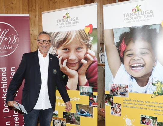 Tabaluga Golf Cup 2021 by Michael Roll For the 27th time Michael Roll organized the Tabaluga Golf Cup for the benefit of his Tabaluga Foundation Michael Roll in front of a poster of the Tabaluga Foundation, Tutzing Bavaria Germany Golfclub Tutzing