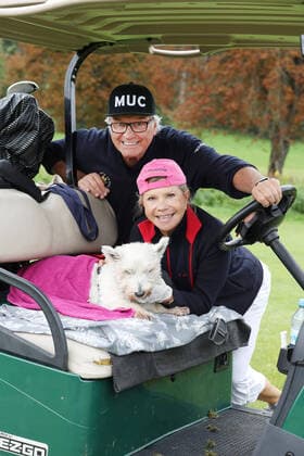 Tabaluga Golf Cup 2021 by Michael Roll For the 27th time Michael Roll organized the Tabaluga Golf Cup for the benefit of his Tabaluga Foundation Marianne and Michael Hartl and their dog Winnie in the Golf Cart, Tutzing Bavaria Germany Golfclub Tutzing