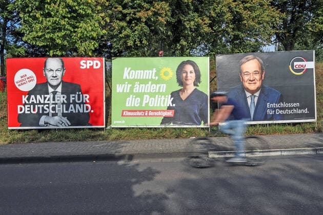 Election posters for the federal election 2021, in the foreground a person rides by on a bicycle, v li of the SPD with the candidate for chancellor Olaf Scholz KANZLER FUER FÜR DEUTSCHLAND WER SCHOLZ WILL, WAEHLT W