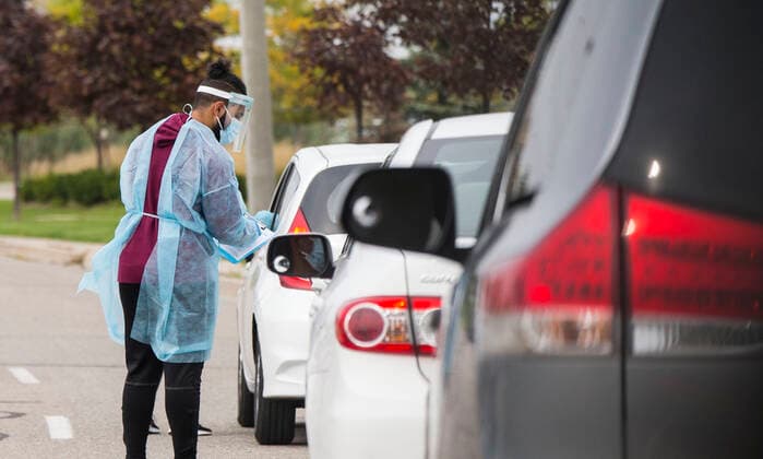 (210914) -- MISSISSAUGA (CANADA), Sept. 14, 2021 -- A medical worker wearing personal protective equipment helps people register outside a drive-thru COVID-19 testing center in Mississauga, Ontario, Canada, on Sept. 14, 2021. Canada s cumulative COVID-19 cases surpassed 1,550,000 as of Tuesday afternoon, with the total hitting 1,553,007, including 27,252 deaths, according to CTV. (Photo by Xinhua) CANADA-ONTARIO-MISSISSAUGA-COVID-19-CASES ZouxZheng