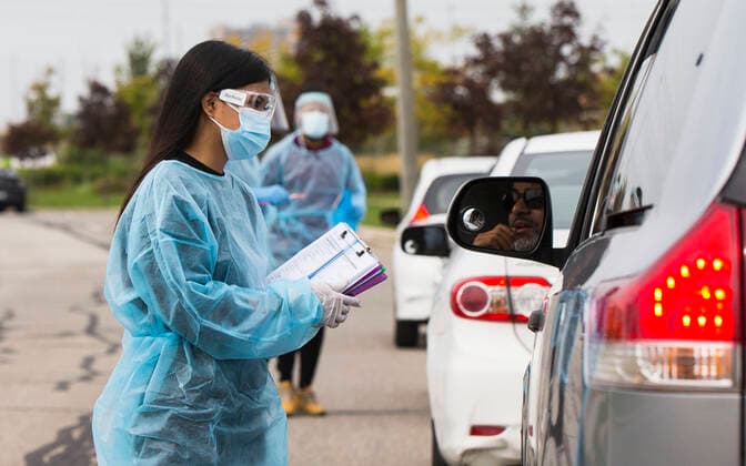 (210914) -- MISSISSAUGA (CANADA), Sept. 14, 2021 -- A medical worker wearing personal protective equipment helps people register outside a drive-thru COVID-19 testing center in Mississauga, Ontario, Canada, on Sept. 14, 2021. Canada s cumulative COVID-19 cases surpassed 1,550,000 as of Tuesday afternoon, with the total hitting 1,553,007, including 27,252 deaths, according to CTV. (Photo by Xinhua) CANADA-ONTARIO-MISSISSAUGA-COVID-19-CASES ZouxZheng