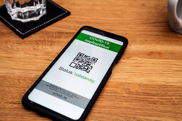 15 September 2021: Digital vaccination certificate, certificate of complete vaccination EU Green Passport or immunity by recovery or test according to 2G and 3G rule on the screen of a smartphone on the table in a restaurant