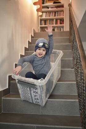 IMAGO Creative: Jahreszeit Winter, Fantasievoll drinnen spielen junge,schlitten fahren,treppenstufen,jungen,rodeln,schlittenfahren,stufe,stufen,treppenstufe *** boy,sledding,stairs,boys,staircase pr8-lgr ,model released, Symbolfoto