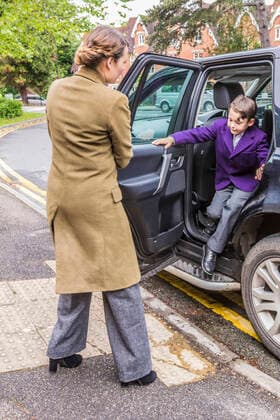 IMAGO Creative: Countdown bis Weihnachten, Nach Hause reisen Mother on school run, opening car door for son, 05.08.2015, Copyright: xGaryxLathamx, model released, wearing,learning,opening,looking down,looking up,full length,rear view,childhood,preparation,routine,bonding,care,development,harmony,nurturing,quality time,support,togetherness,love,a helping hand,child,10 to 11 years,female,woman,male,boy,pre-adolescent boy,two people,student,school,outdoors,day,street,raincoat,jacket,trousers,uniform,education,standing,family,two generation family,son,mother,single parent,journey,transport,car,automobile door,family with one child,obscured face,comfort,relationship,vehicle,both male and female,winter coat,alighting,August 2015 Release,school run,buildings,Opening,Standing,Thinking,Learning,Looking Dow Ref:IS09AS82I