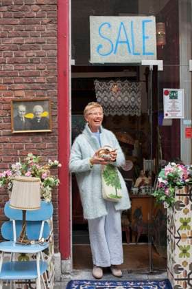Mature female customer holding teapot outside vintage shop, 07.12.2015, Copyright: xFrankxVanxDelftx, model released, , property released, buying,wearing,holding,shopping,blond hair,front view,full length,small business,abundance,consumerism,retro,style,indulgence,happiness,vintage,teapot,caucasian ethnicity,female,woman,mature woman,only one mature woman,customer,shopper,one person,outdoors,day,street,casual clothing,eyeglasses,smiling,short hair,quaint,sale,treat,only female,55 to 59 years,shop front,trouser suit,second hand,vintage shop,December 2015 Release,goods,Buying,Shopping,Holding,Caucasian Ethnicity,Mature Adult,55-59 Years,Female,Women,Customer,Abundance,Consumerism,Indulgence,Style,Wellbeing,Happiness,Short Hair,One Person,Ol Ref:IS09AU8GT