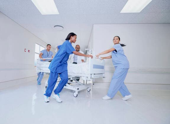 Doctor and medical running with patient bed in hospital emergency, 15.09.2016, Copyright: xFrankxandxHelenax, model released, wearing,running,working,blue,white color,full length,problem,authority,concentration,responsibility,cooperation,efficiency,effort,skill,support,teamwork,unity,confidence,on the go,indian ethnicity,caucasian ethnicity,mixed race ethnicity,multi-ethnic group,woman,mid adult woman,young woman,man,mature man,mid adult man,five people,medical occupation,doctor,nurse,corridor,indoors,south africa,hospital,action,medical clothing,surgical scrubs,protective clothing,energy,medicine,speed,hospital bed,patient,emergency,both male and female,health-and-safety,paarl,healthcare,September 2016 Release,Running,Thinking,Concentra Ref:IS09B23WG