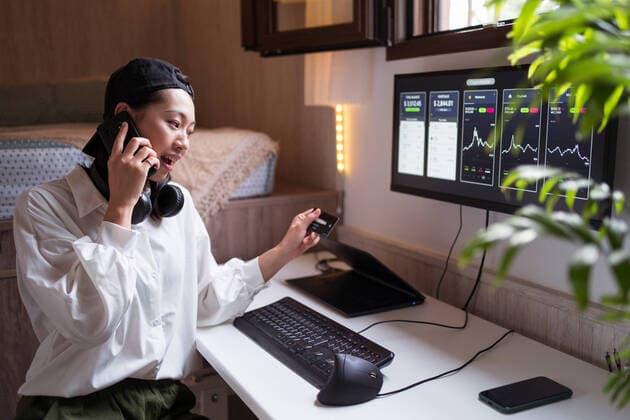 IMAGO Creative: Digitale Welt, Social Commerce Surprised Asian female trader speaking on smartphone and looking at credit card while working with cryptocurrency statistic, Model released, Property released JuanAlbertoRuiz_Cryptocurrencies_14.jpg Copyright: xJuanxAlbertoxRuizx MR