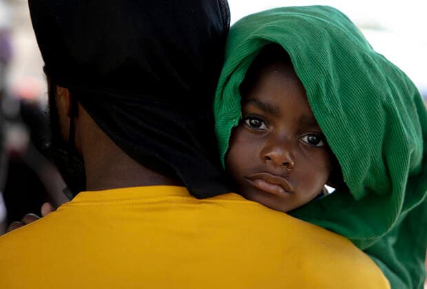 (210925) -- CIUDAD ACUNA (MEXICO), Sept. 25, 2021 -- A Haitian migrant boy and his father wait in line to give Mexican immigration officials their information at a shelter in Ciudad Acuna, Mexico, on Sept. 25, 2021. U.S.-Mexico border arrests have reportedly stayed at the highest level in more than two decades, with more than 208,000 registered in August alone. (Photo by Xinhua) MEXICO-CIUDAD ACUNA-U.S.-BORDER-MIGRANTS NickxWagner 