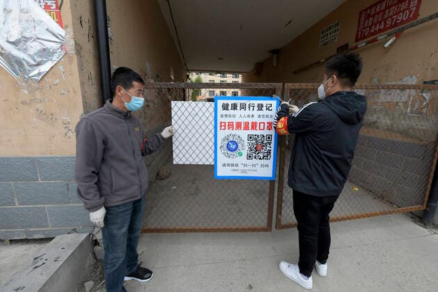 Coronavirus in China, Eindrücke aus Harbin (210926) -- HARBIN, Sept. 26, 2021 -- Volunteers close a gate of a residential area for epidemic prevention and control in Xinglong Town of Bayan County, northeast China s Heilongjiang Province, Sept. 25, 2021. A high-risk area in Xinglong Town of Bayan County was added in Harbin on Saturday. ) CHINA-HEILONGJIANG-BAYAN-COVID-19 (CN) WangxJianwei 