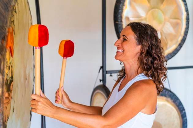 Smiling female therapist playing percussion musical instrument at studio model released Symbolfoto property released DLTSF02120