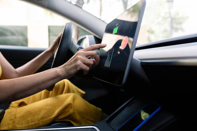 Woman using digital tablet while driving electric car model released Symbolfoto property released JCCMF03711