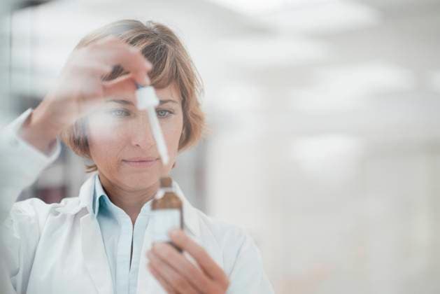 Female pharmacist with pipette examining at laboratory model released Symbolfoto property released JOSEF05439
