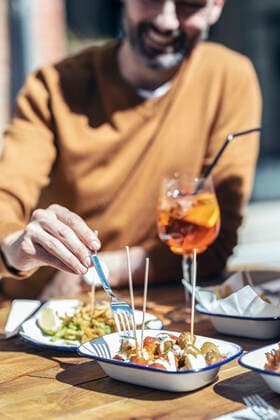 IMAGO Creative, Food, Tapas Smiling man eating tapas at restaurant model released Symbolfoto property released JSRF01607