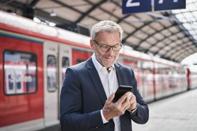 IMAGO Creative: Neue Aussichten Male professional using mobile phone while standing on railroad platform model released Symbolfoto RORF02834