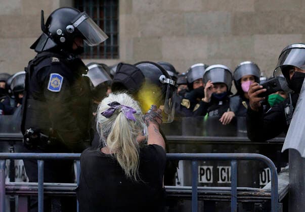 Global Day Of Action In Favour Of Legal, Free And Safe Abortion In Mexico And Latin America An elderly woman belonging to a feminist group, sprays paint on police officers guarding the National Palace in the Zocalo of Mexico City, on the occasion of the Global Day of Action in favour of legal, free and safe abortion in Mexico and Latin America. Mexico City Mexico vieyra-notitle210928_npLyo  Copyright: xGerardoxVieyrax