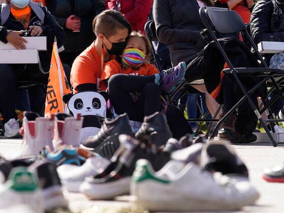 September 30, 2021, Ottawa, on, Canada: A woman and her daughter sit behind a display of children s shoes during the National Day for Truth and Reconciliation in Ottawa on Thursday, Sept. 30, 2021. Ottawa Canada  - ZUMAc35_ 20210930_zaf_c35_014 Copyright: xAdrianxWyldx