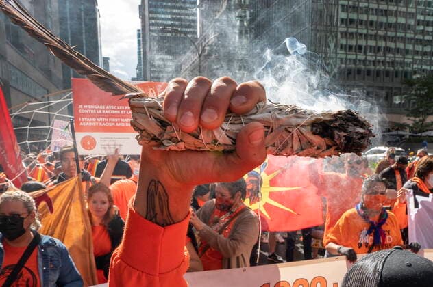 News Bilder des Tages September 30, 2021, Montreal, PQ, Canada: A man holds up an eagle feather and burns sweet grass as people take part in a march to mark the first National Day for Truth and Reconciliation Thursday, September 30, 2021 in Montreal. Montreal Canada  - ZUMAc35_ 20210930_zaf_c35_094 Copyright: xRyanxRemiorzx