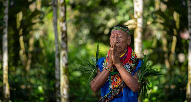 Cofan indigenous shaman praying with hands joined in Amazon rainforest Nueva Loja, Sucumbios, Ecuador CR_RMWG210906-826963-01 EDITORIAL USE ONLY