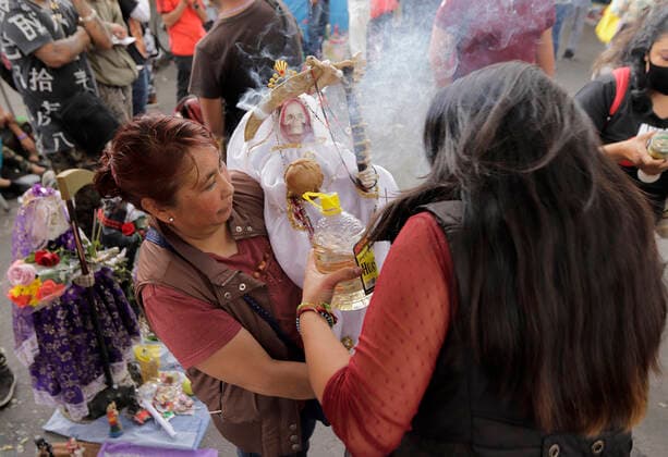Followers Of Santa Muerte Call For An End To The Pandemic In Mexico A woman carries a figure of Santa Muerte outside her temple in Tepito, Mexico City, where several of her followers gathered to give thanks for the favours granted by La Nina Blanca during the COVID-19 health emergency in Mexico and the yellow epidemiological traffic light in the capital. Mexico City Mexico vieyra-notitle211001_npImb  Copyright: xGerardoxVieyrax