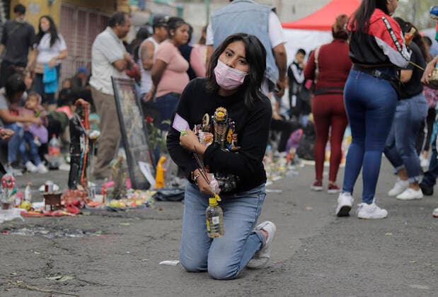 Followers Of Santa Muerte Call For An End To The Pandemic In Mexico Followers of Santa Muerte kneeling outside her temple in Tepito, Mexico City, gathered to give thanks for the favours granted by La Nina Blanca during the COVID-19 health emergency in Mexico and the yellow epidemiological traffic light in the capital. Mexico City Mexico vieyra-notitle211001_np6ua  Copyright: xGerardoxVieyrax