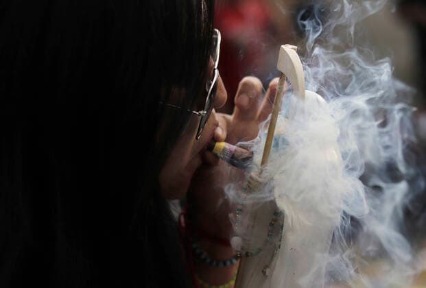 Followers Of Santa Muerte Call For An End To The Pandemic In Mexico A woman blows smoke over a figure of Santa Muerte outside her temple in Tepito, Mexico City, where several of her followers gathered to give thanks for the favours granted by La Nina Blanca during the COVID-19 health emergency in Mexico and the yellow epidemiological traffic light in the capital. Mexico City Mexico vieyra-notitle211001_npsxX  Copyright: xGerardoxVieyrax