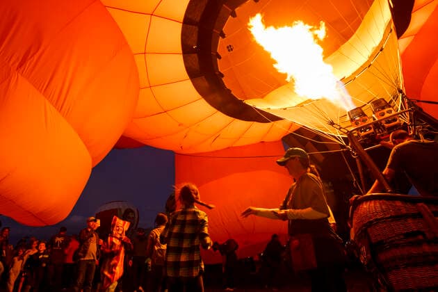 October 2, 2021, albuquerque, New Mexico, USA: A kid in a bacon costume runs under Pigasus as Tyler Jacques pumps the gas during the Twilight Twinkle Glow on the first night of the Albuquerque International Balloon Fiesta on Saturday, Oct. 2, 2021. During the Glow many of the balloons are inflated and lit up as the sun goes down. for the Albuquerque Journal albuquerque USA - ZUMAab1_ 20211002_zaf_ab1_029 Copyright: xNadavxSorokerx