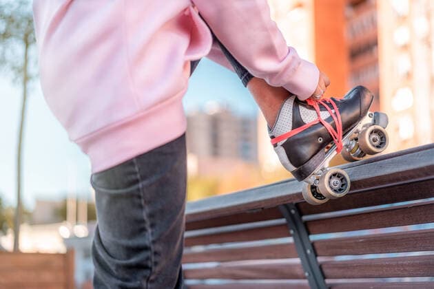 IMAGO Creative: Digitale Welt, Verzicht auf Technologie Side view of cropped unrecognizable young female wearing light pink hoodie and black trousers lacing up roller skates leaning leg on back of wooden bench in part, Model released EnriqueEspinosa_UrbanSkating_EnriqueEspinosaTellez_PatinajeUrbano_9.jpg Copyright: xEnriquexEspinosax MR