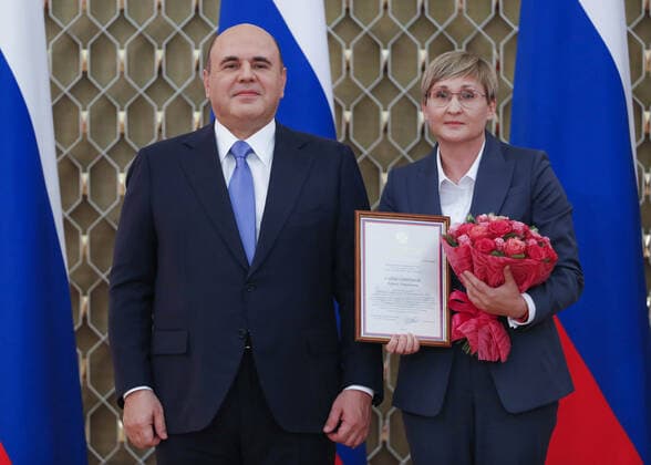 MOSCOW, RUSSIA - OCTOBER 5, 2021: Russia s Prime Minister Mikhail Mishustin (L) poses with Tatyana Saifutdinova, Director for Educational Programmes at the Orlyonok Russian Children s Centre, during a ceremony to award commendations and state prizes in the field of education and mark Teachers Day. Dmitry Astakhov POOL TASS  TS113222