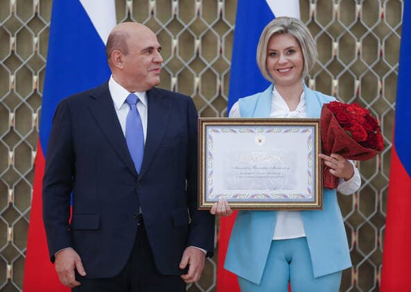 MOSCOW, RUSSIA - OCTOBER 5, 2021: Russia s Prime Minister Mikhail Mishustin (L) poses with Viktoria Maksimova, history and social science teacher at Moscow Region s Detgorodkovskaya secondary school, during a ceremony to award commendations and state prizes in the field of education and mark Teachers Day. Dmitry Astakhov POOL TASS  TS113243