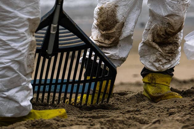 October 4, 2021, Huntington Beach, California, USA: A worker in a protective suit cleans up an area of the beach after a major oil spill dumped 126,000-gallon oil from an offshore oil platform. A massive oil spill off the Orange County coast in Southern California prompted the closure of a 9-kilometer long beachfront area and crews from the California Department of Fish and Wildlife (CDFW) are cleaning up the pollution from facilities in federal waters. Huntington Beach USA - ZUMAr145 20211004_new_r145_052 Copyright: xJasonxRyanx
