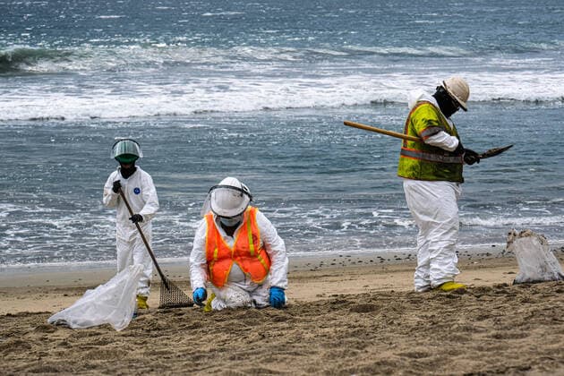 October 4, 2021, Huntington Beach, California, USA: Workers clean up an area of the beach after a major oil spill dumped 126,000-gallon oil from an offshore oil platform. A massive oil spill off the Orange County coast in Southern California prompted the closure of a 9-kilometer long beachfront area and crews from the California Department of Fish and Wildlife (CDFW) are cleaning up the pollution from facilities in federal waters. Huntington Beach USA  - ZUMAr145 20211004_new_r145_036 Copyright: xJasonxRyanx