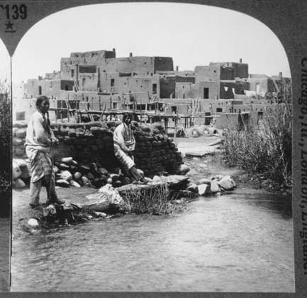 IMAGO Cultures of the world, Taos Pueblo in New Mexico, USA Two Native Americans Standing Next to Stream, Taos Pueblo, New Mexico, USA, Single Image of Stereo Card, 1900  Copyright: xJTxVintagex xGlasshousexImagesx jtv002910
