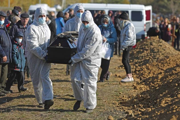 OMSK, RUSSIA â€“ OCTOBER 9, 2021: Cemetery workers in protective gear bury people who died of causes related to COVID-19 at Novo-Yuzhnoye Cemetery. Yevgeny Sofiychuk TASS  TS11395F