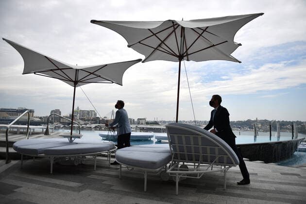 NSW CORONAVIRUS COVID19 REOPENING, Workers begin reopening preparation by setting up pool umbrellas at Crown Sydney in Sydney, Sunday, October 10, 2021. From Monday, lockdown restrictions will lift for fully vaccinated people across NSW. ( NO ARCHIVING, EDITORIAL USE ONLY, NO USE IN BOOKS WITHOUT CONSENT SYDNEY NSW AUSTRALIA  Copyright: xJOELxCARRETTx 20211010001584634355